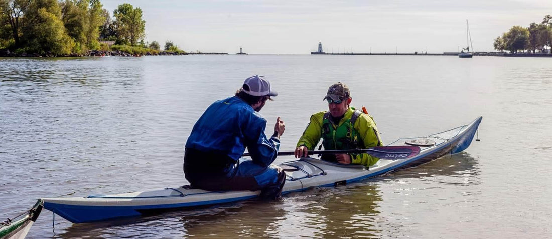 A coach and a student in a sea kayak on moving water