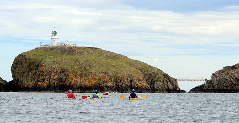 A group sea kayaking along the Pembrokeshire coast